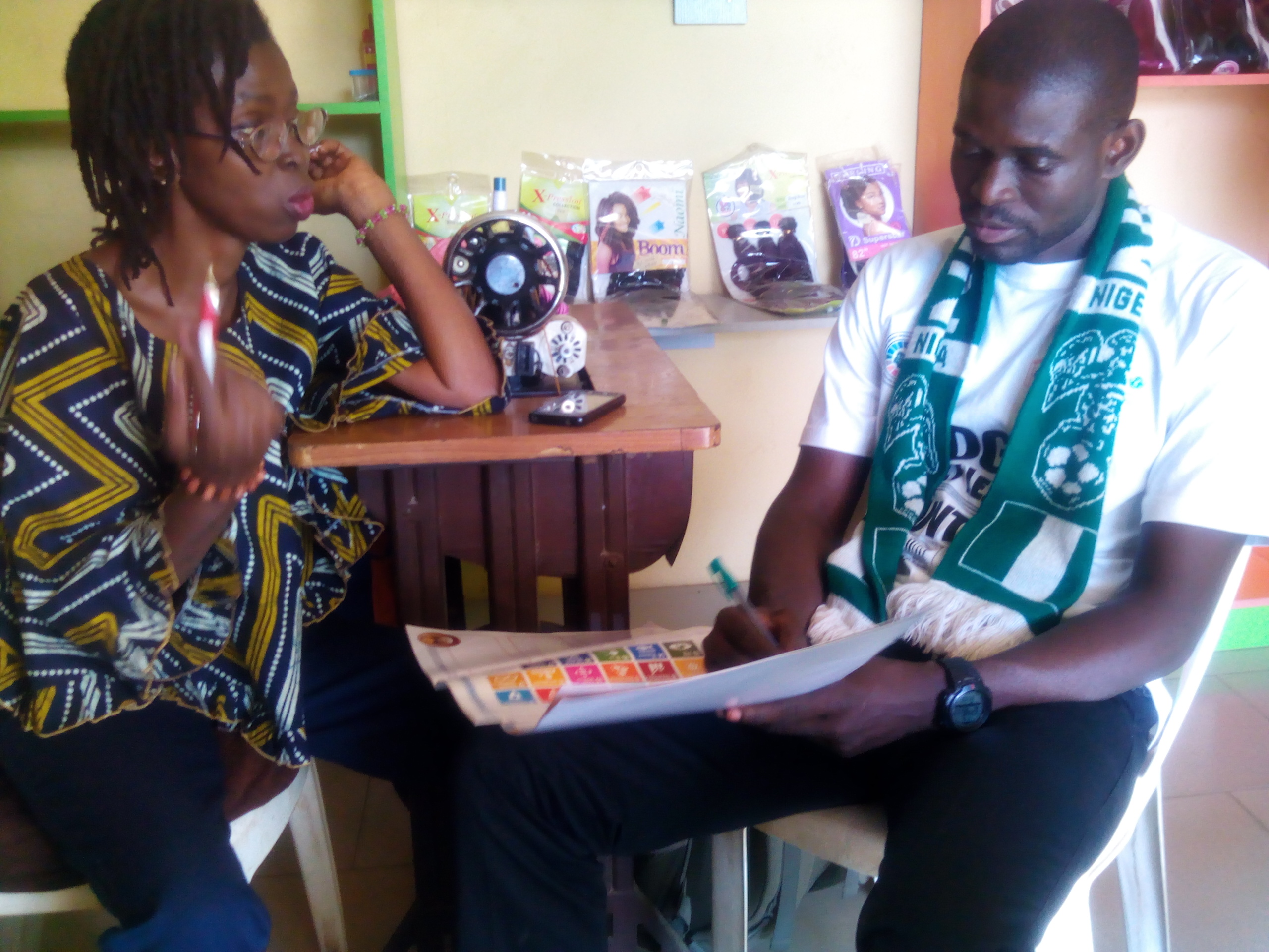 amos educating a middle age woman on the sdgs