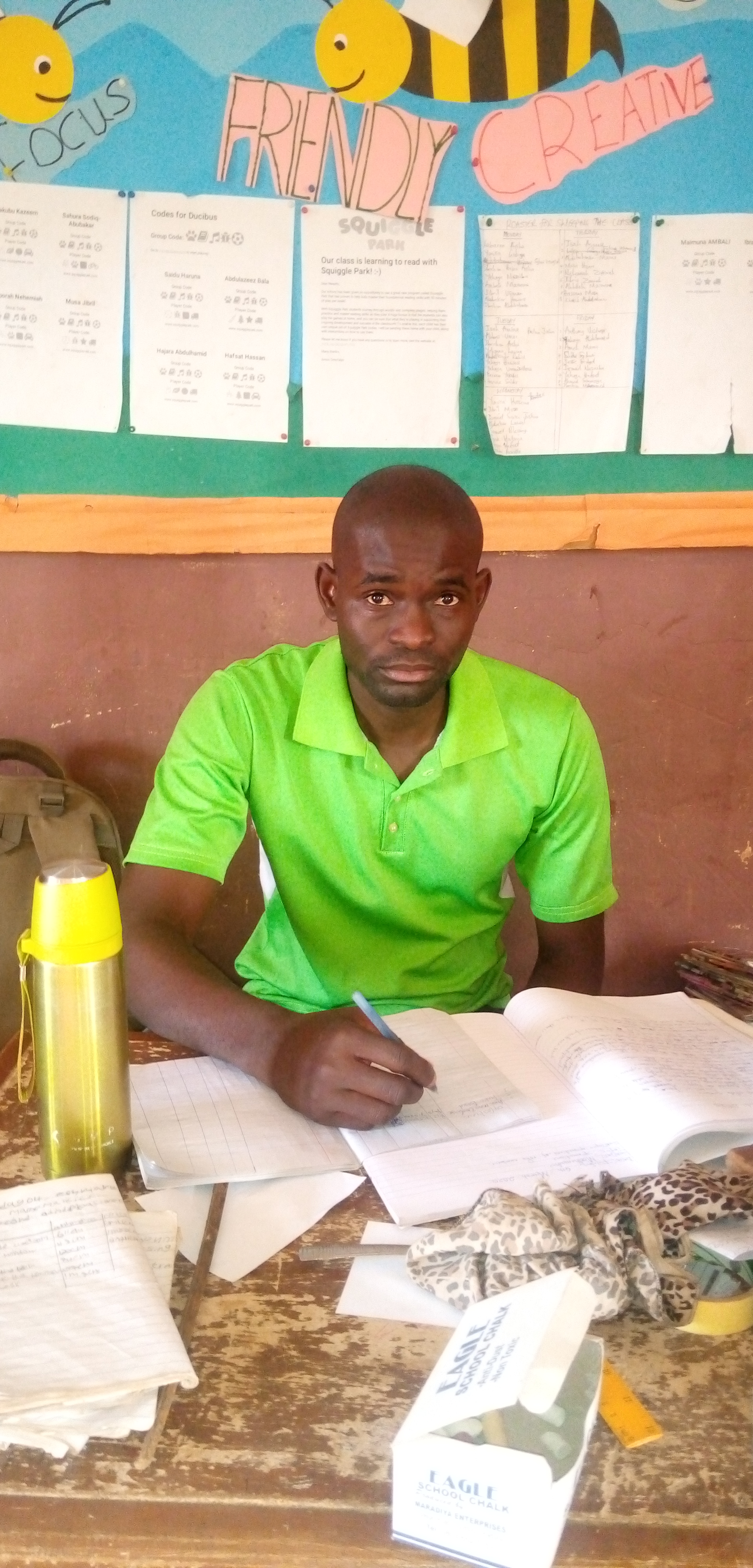 Amos sitting at his desk preparing for class